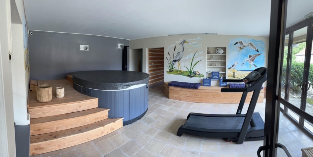 Vue d'ensemble de l'espace détente avec le jacuzzi et le tapis de course