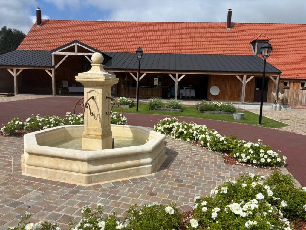 Fontaine et parterre fleuri dans la cours d'honneur de la Grange aux Belles
