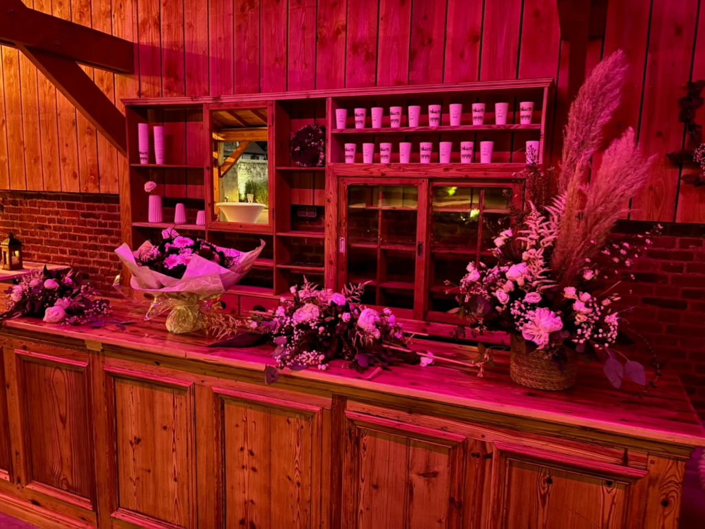 Bar extérieur illuminé en soirée sous la terrasse couverte